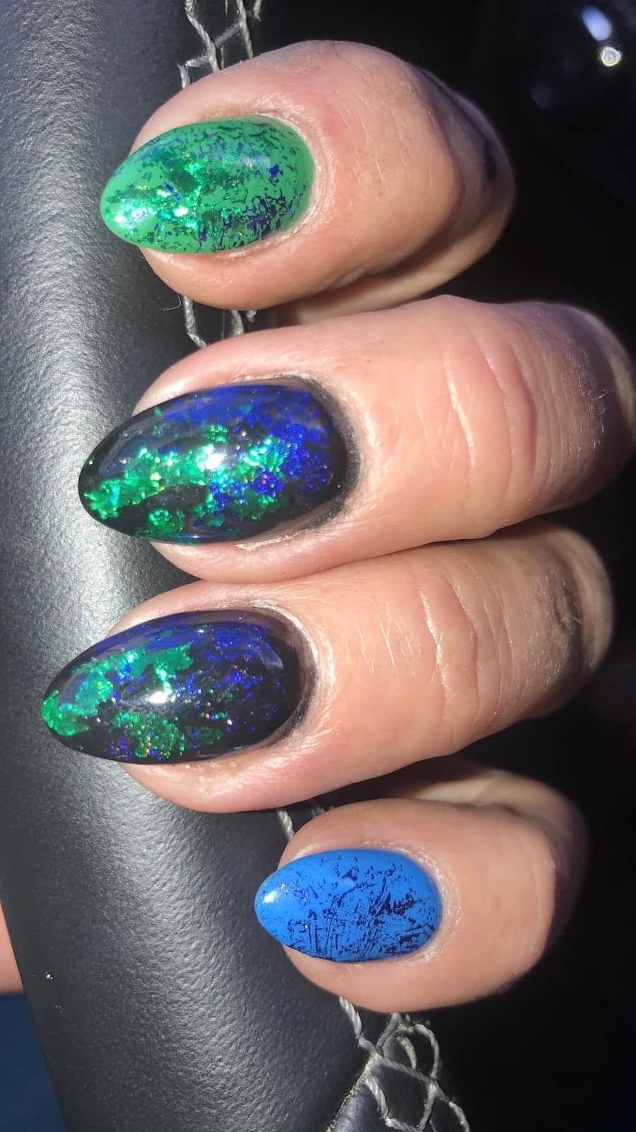 Mandelförmige Nägel mit grün-blauem Galaxy-Effekt auf Schwarz