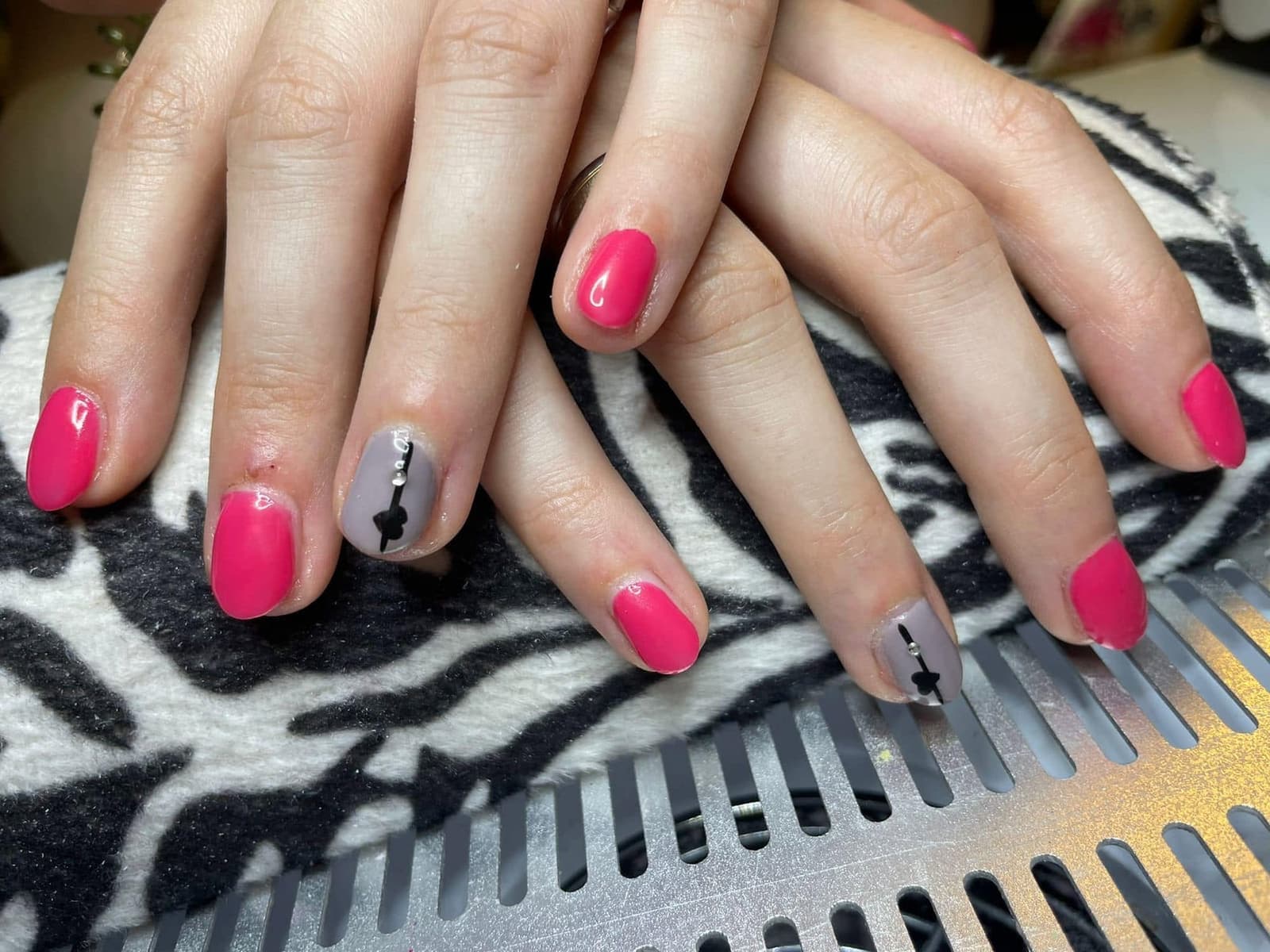 Pinke Nägel mit einem Akzentnagel in Nude und schwarzem Detail