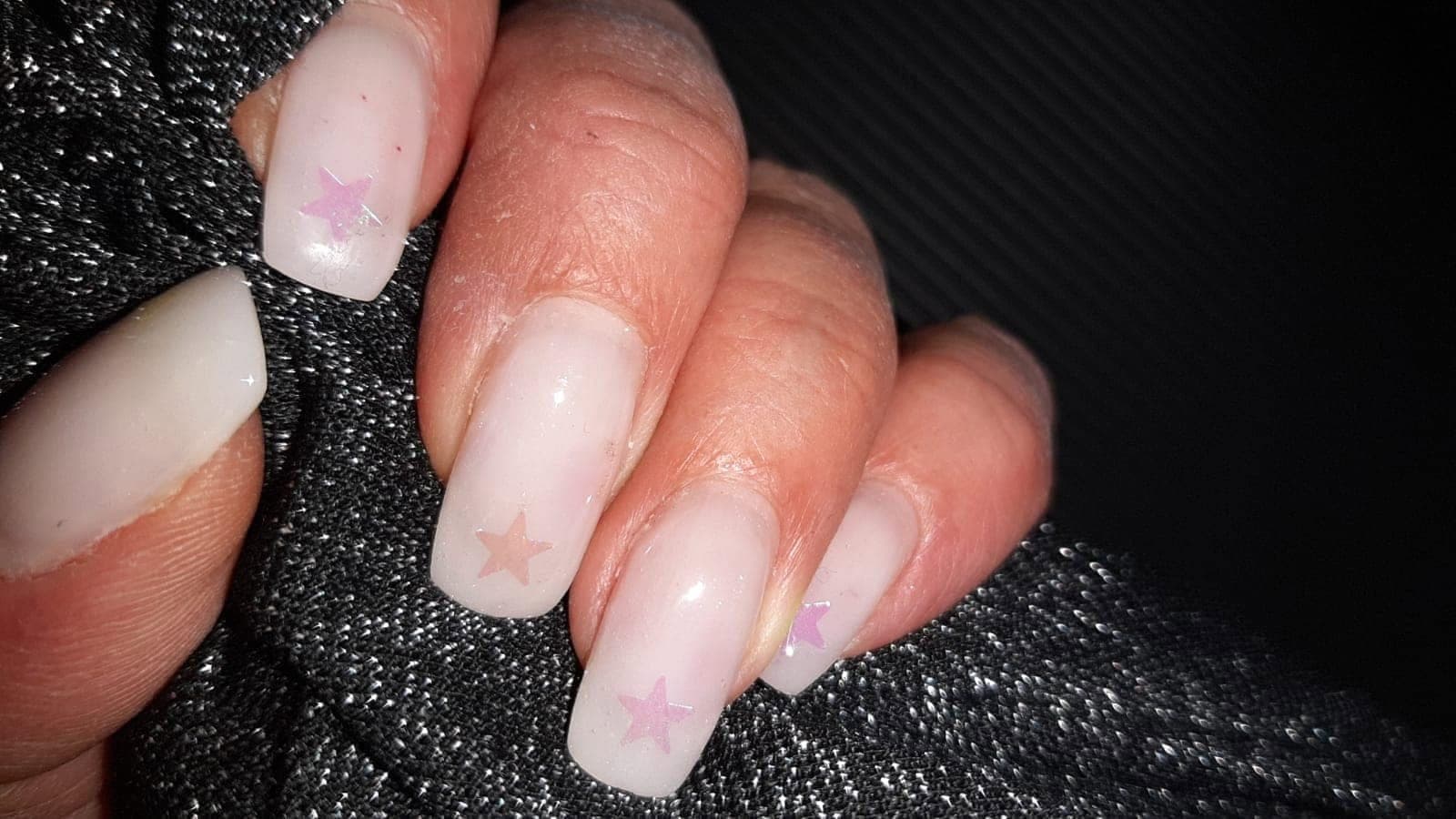 Natürliche Nägel in Nude mit zarten Sternen, klare Form